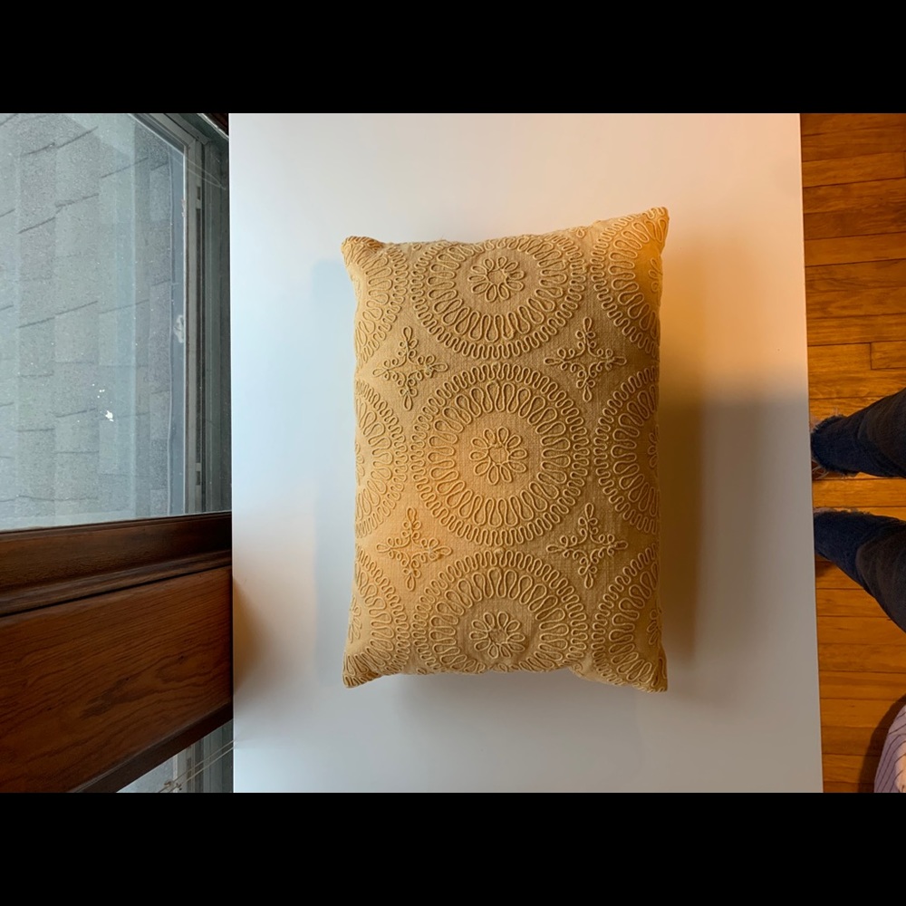 Yellow throw pillow with embroidery